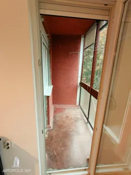 Pogled iz stana na praznu zatvorenu terasu sa crvenim zidovima. - image 8
