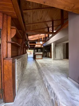 Covered porch with wooden structure and stone cladding. - image 4