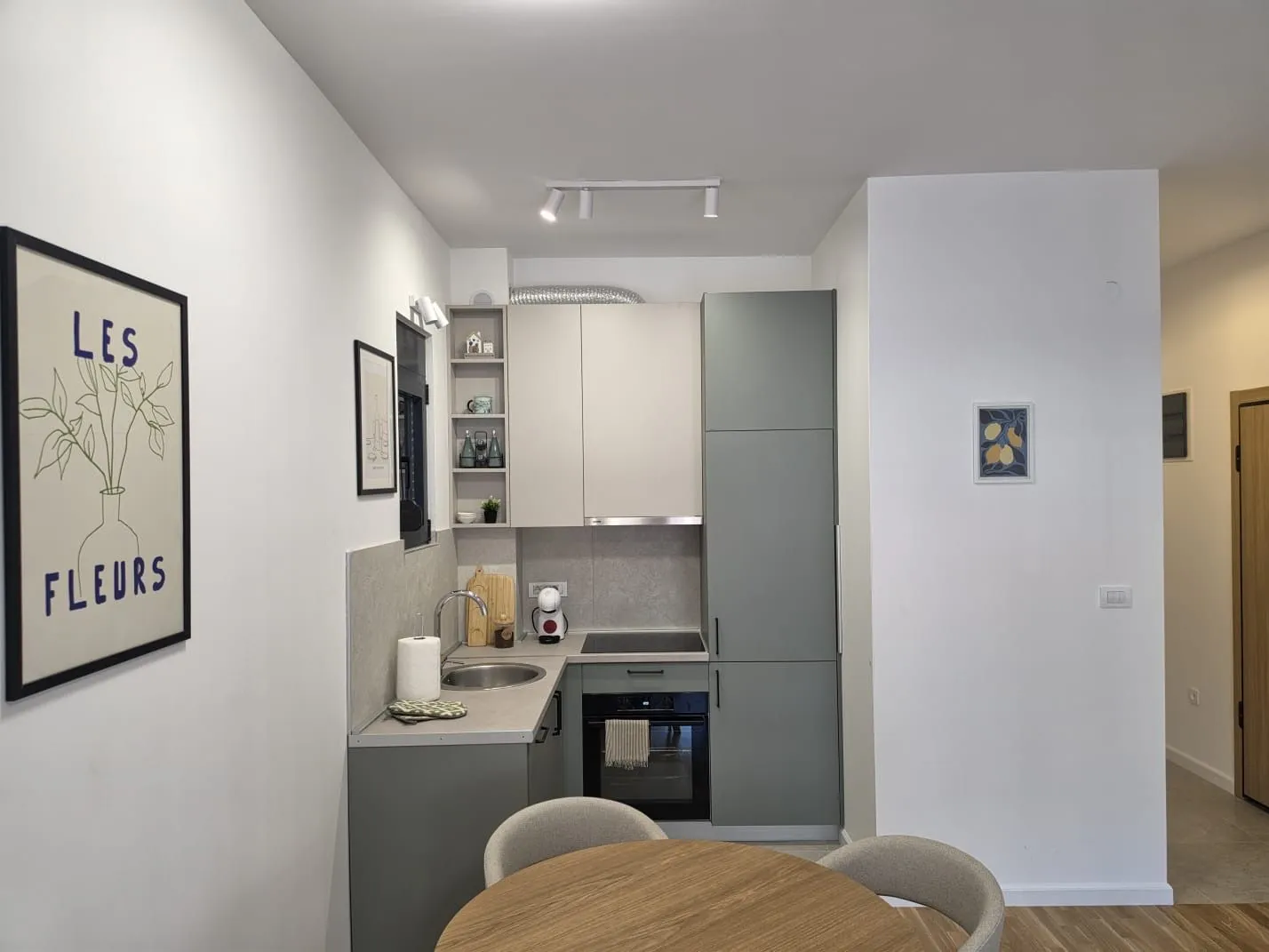 Modern kitchen with grey cabinets and a dining table in the foreground.
