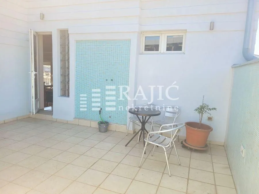 Spacious terrace with patio furniture and tiled flooring.