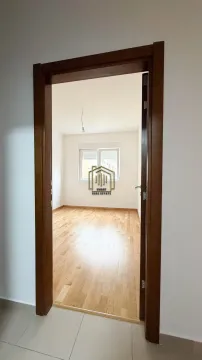 Pogled kroz vrata na praznu sobu sa drvenim podom. - image 8
