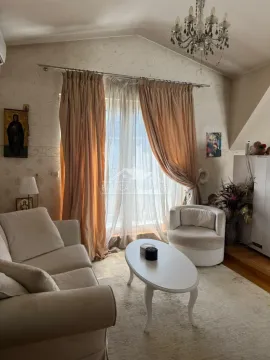 Dnevna soba sa garniturom, stočićem i prozorom sa zavesama. - image 2