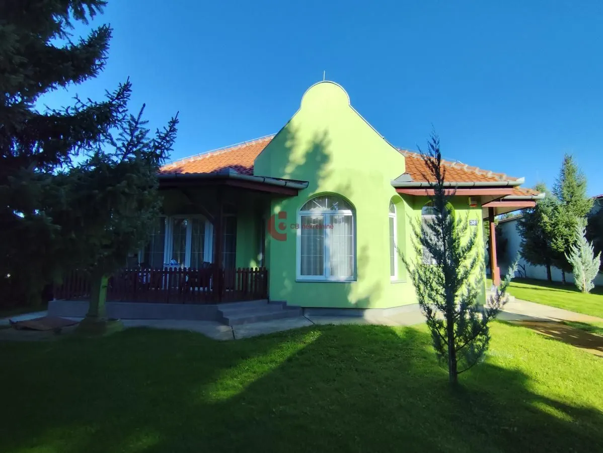 View of the front facade of the house and landscaped yard with greenery.