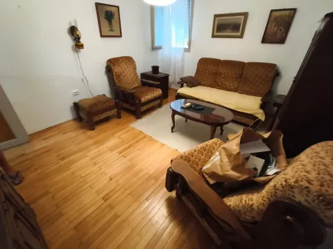 Dnevna soba sa garniturom za sedenje, drvenim podom i slikama na zidu. - image 2