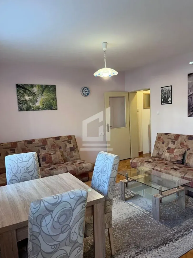 Living room with a sofa set, dining table and a glass coffee table.