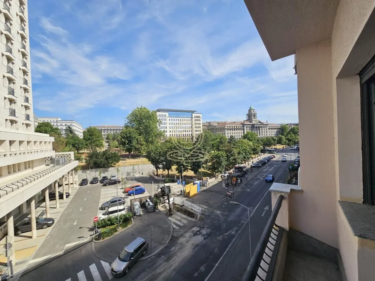 Pogled sa terase na gradsku ulicu, parking i okolne zgrade.