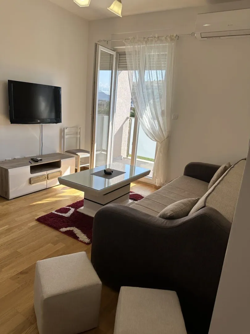 Living room with a sofa and balcony access.