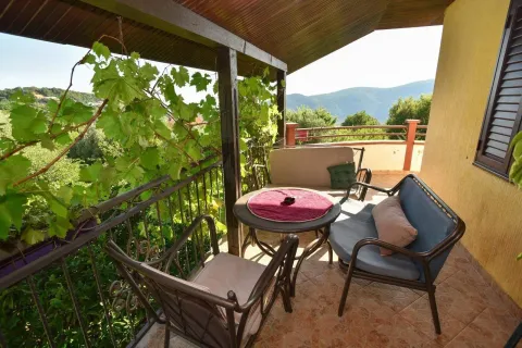 Covered balcony with seating furniture and nature view. - image 5