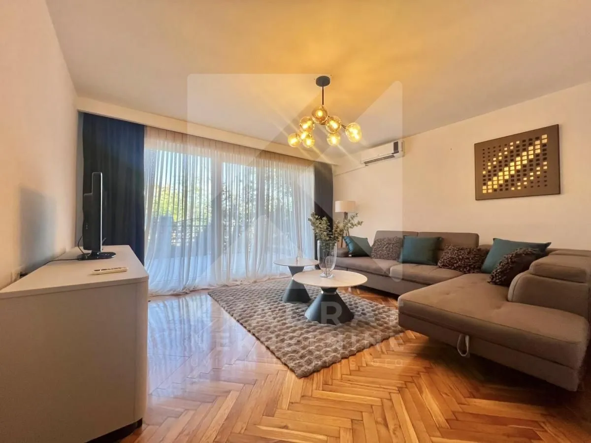 Living room with a sofa, TV, and access to the terrace.