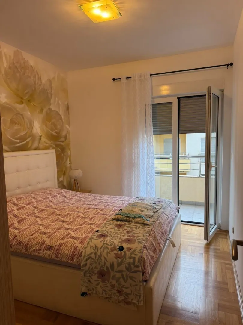 Furnished bedroom with a double bed and access to the balcony.