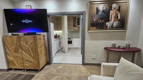 Dnevna soba sa televizorom i pogledom na kuhinju u pozadini. - image 3