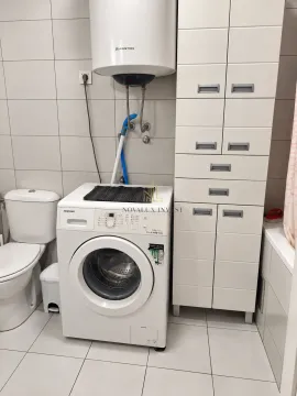 Kupatilo opremljeno sanitarijama, veš mašinom i bijelim ormarićem. - image 8