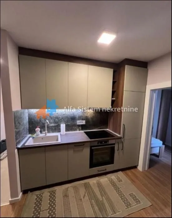 Small kitchen with a sink, built-in oven, and upper and lower cabinets.