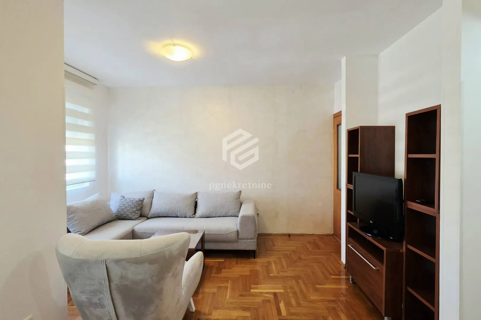 Living room with sofa, armchair and TV unit.
