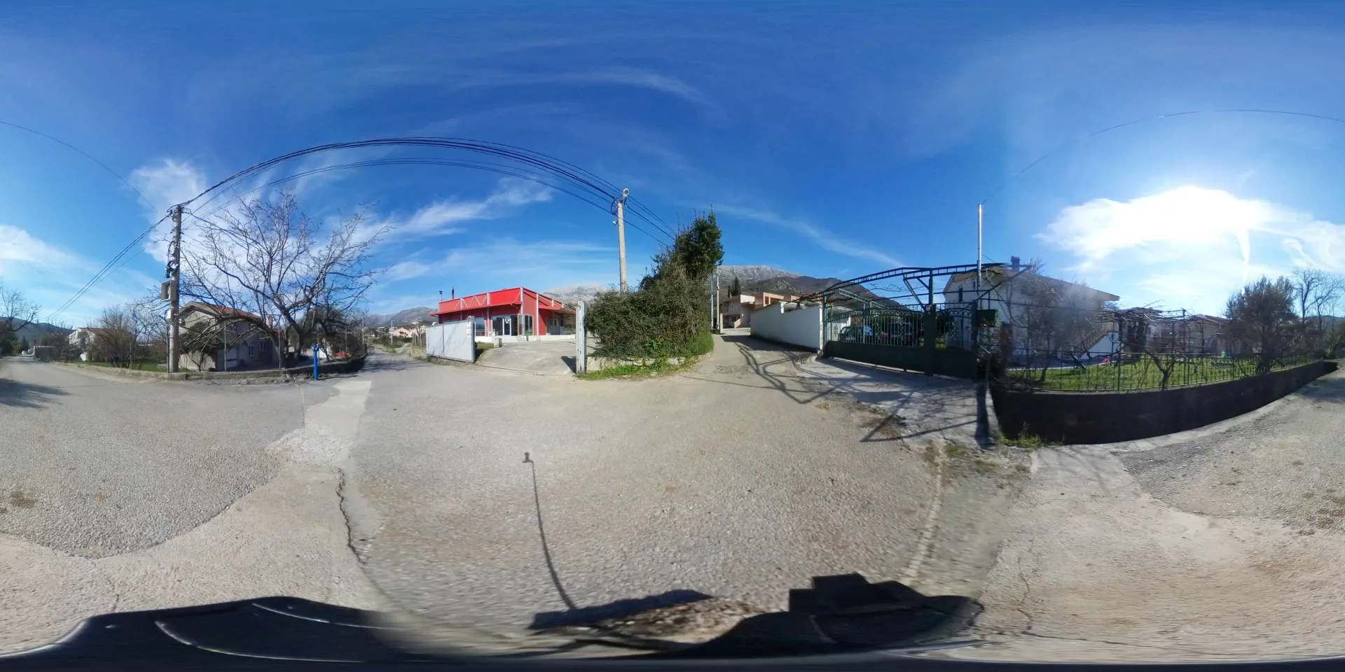 Panoramic view of the street and surrounding area with houses and yards.