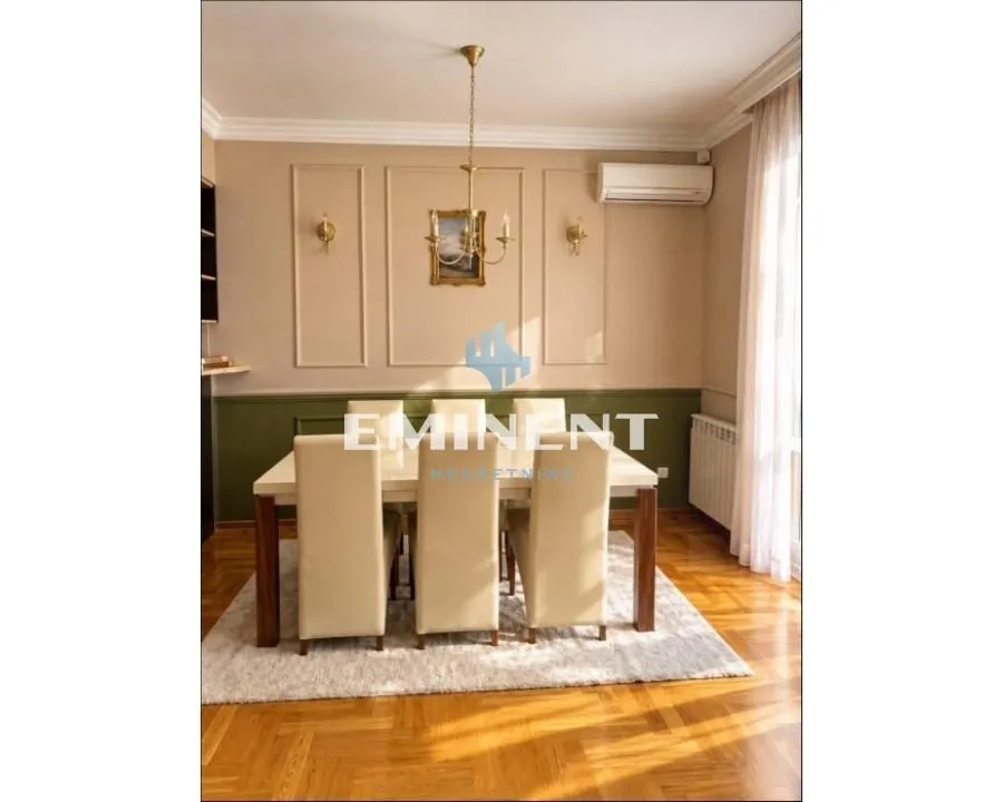 Dining area with a table, chairs, and decorative wall moldings.