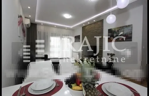 Living room with dining area and modern lighting.