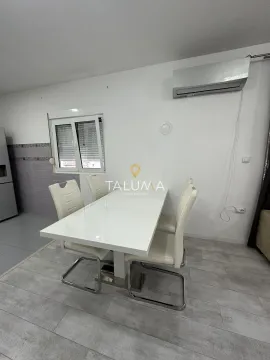 Dining area with a white table and four chairs. - image 8