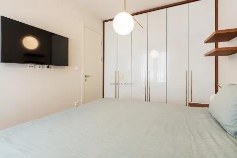 Moderna spavaća soba sa bračnim krevetom, ugradnim plakarom i televizorom na zidu. - image 7