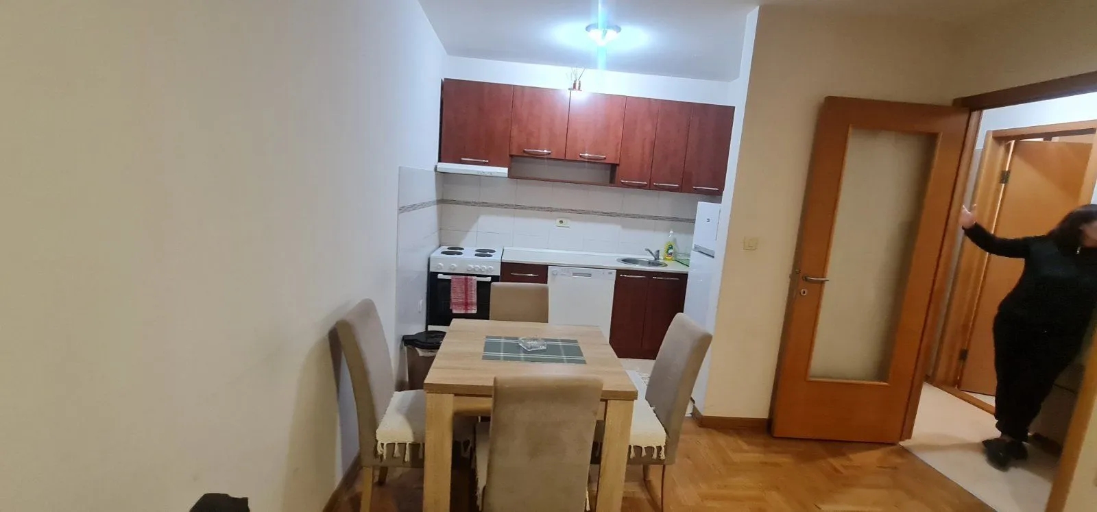 Kuhinja sa trpezarijskim stolom i stolicama u stanu.