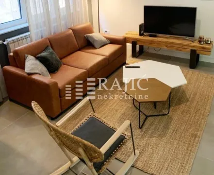 Living room furnished with a sofa, armchair, and TV unit. - image 3