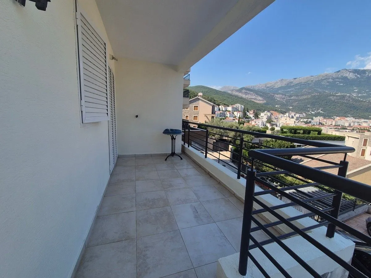 Spacious covered terrace with a view of the city and mountains.