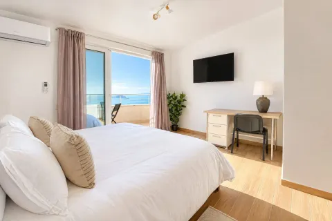 Bright bedroom with a double bed, desk, and access to a terrace with a sea view. - image 9