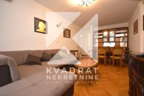 Living room with a sofa seating area and a dining space in the background. - image 3