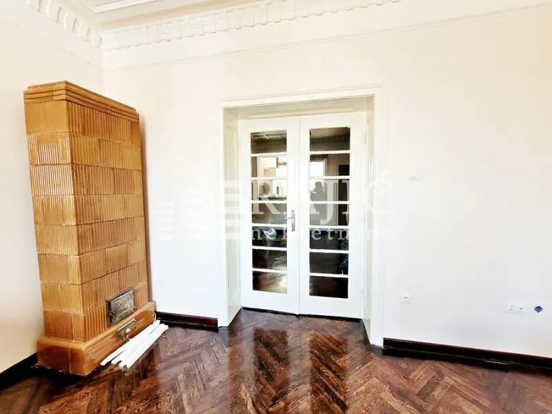 Interior of a room with a wood-burning stove and wooden flooring.