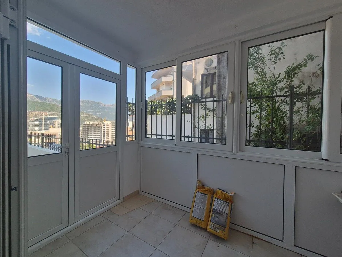Glazed terrace with a view of the city and surrounding buildings.