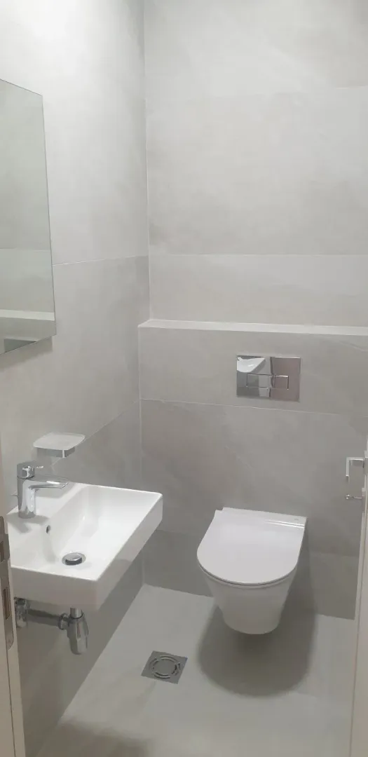 Small, modern bathroom with light-colored tiles.