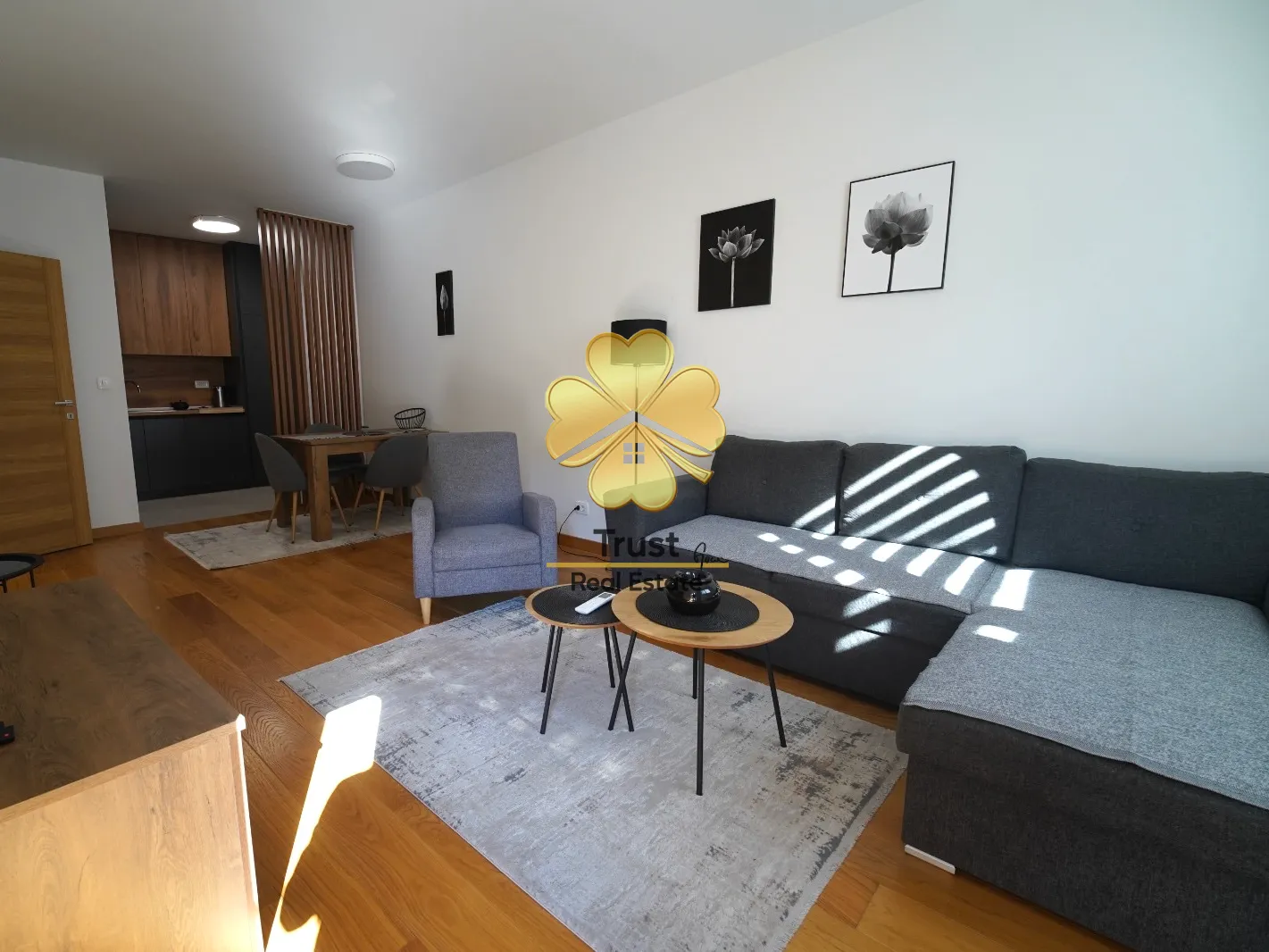 Living room with sofa, dining area, and kitchen in the background.