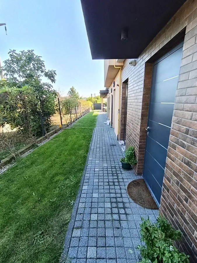Paved path and lawn by the building entrance.