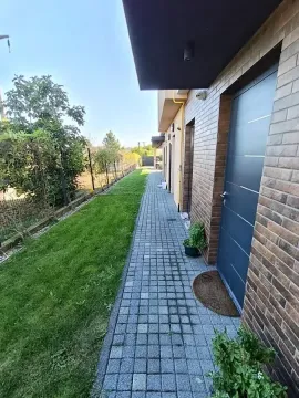 Paved path and lawn by the building entrance. - image 5