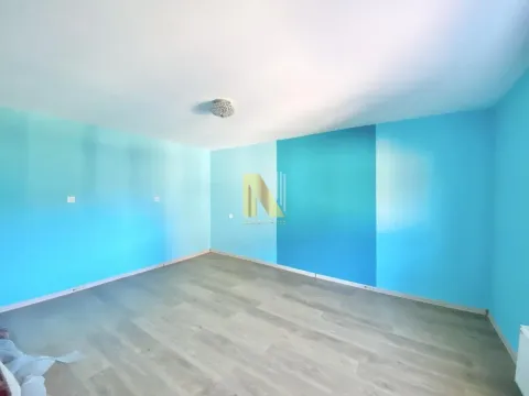 Prazna soba sa plavim zidovima i svetlim laminatom. - image 12