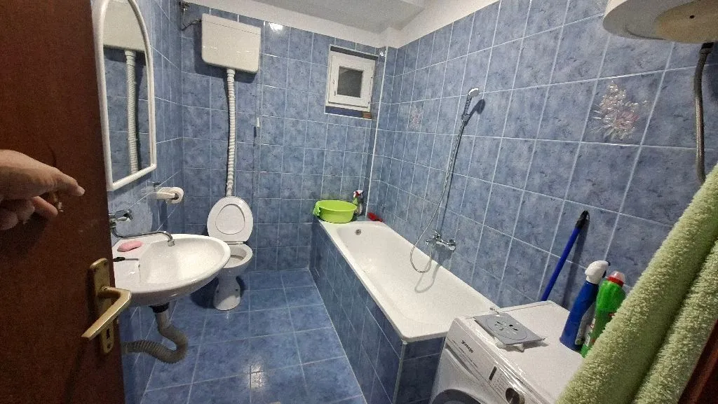 Bathroom with blue tiles, bathtub, washbasin, and toilet.