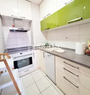 Compact equipped kitchen with white and green cabinetry. - image 9