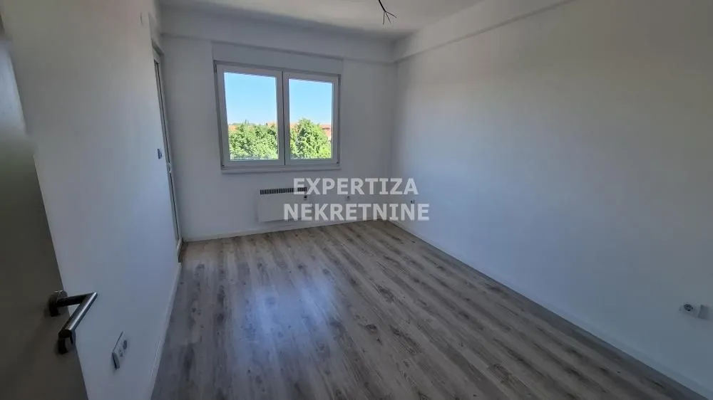 Empty room with laminate flooring and a window.