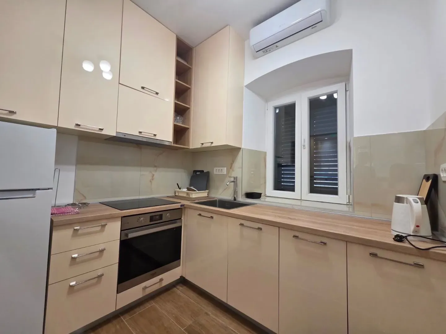 Modern kitchen with light cabinetry and built-in appliances.