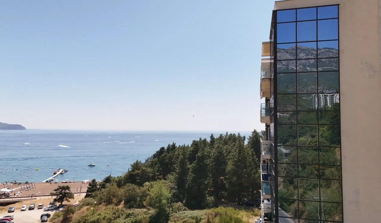 Pogled sa terase na more, plažu i okolno zelenilo.