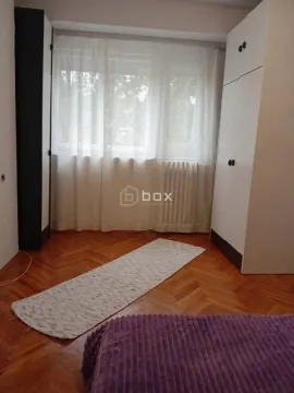 Spavaća soba sa krevetom, plakarima i prozorom sa belim zavesama. - image 10