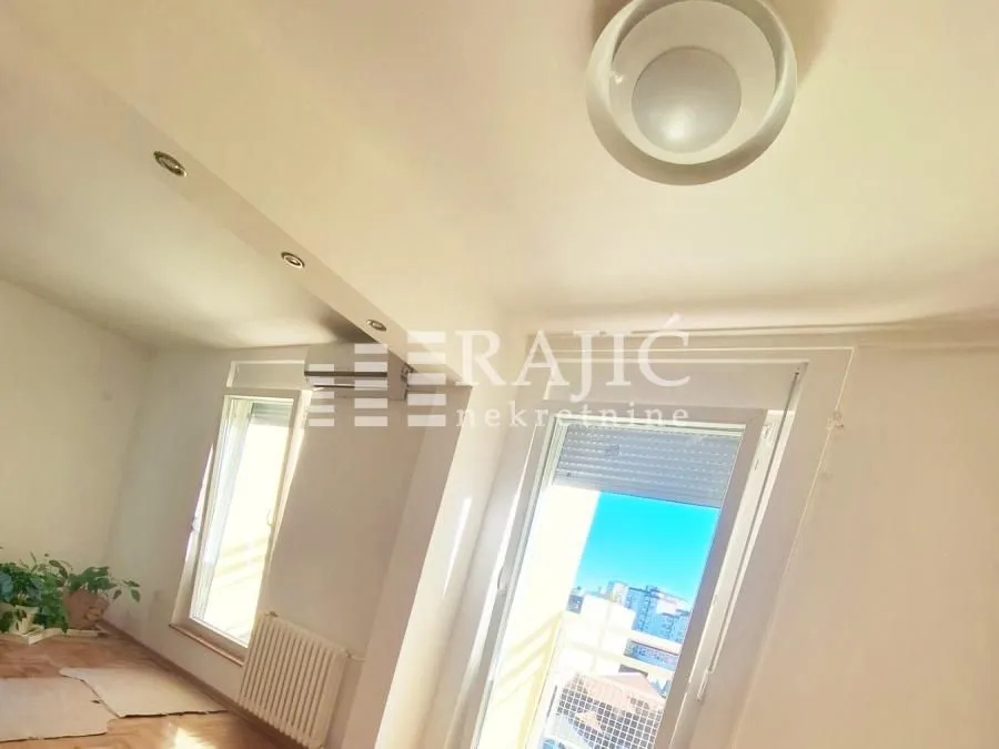Bright living room with windows and laminate flooring.