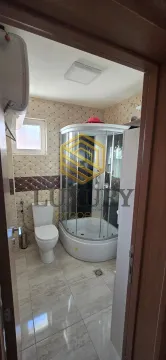 View of the bathroom with a shower cabin through an open door. - image 10