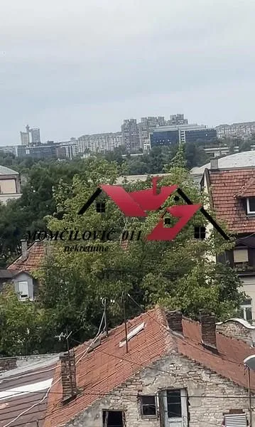 Pogled sa prozora na okolne zgrade i gradsko naselje.