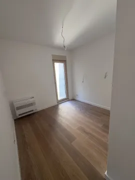 Prazna soba sa svijetlim zidovima, drvenim podom i balkonskim vratima. - image 12