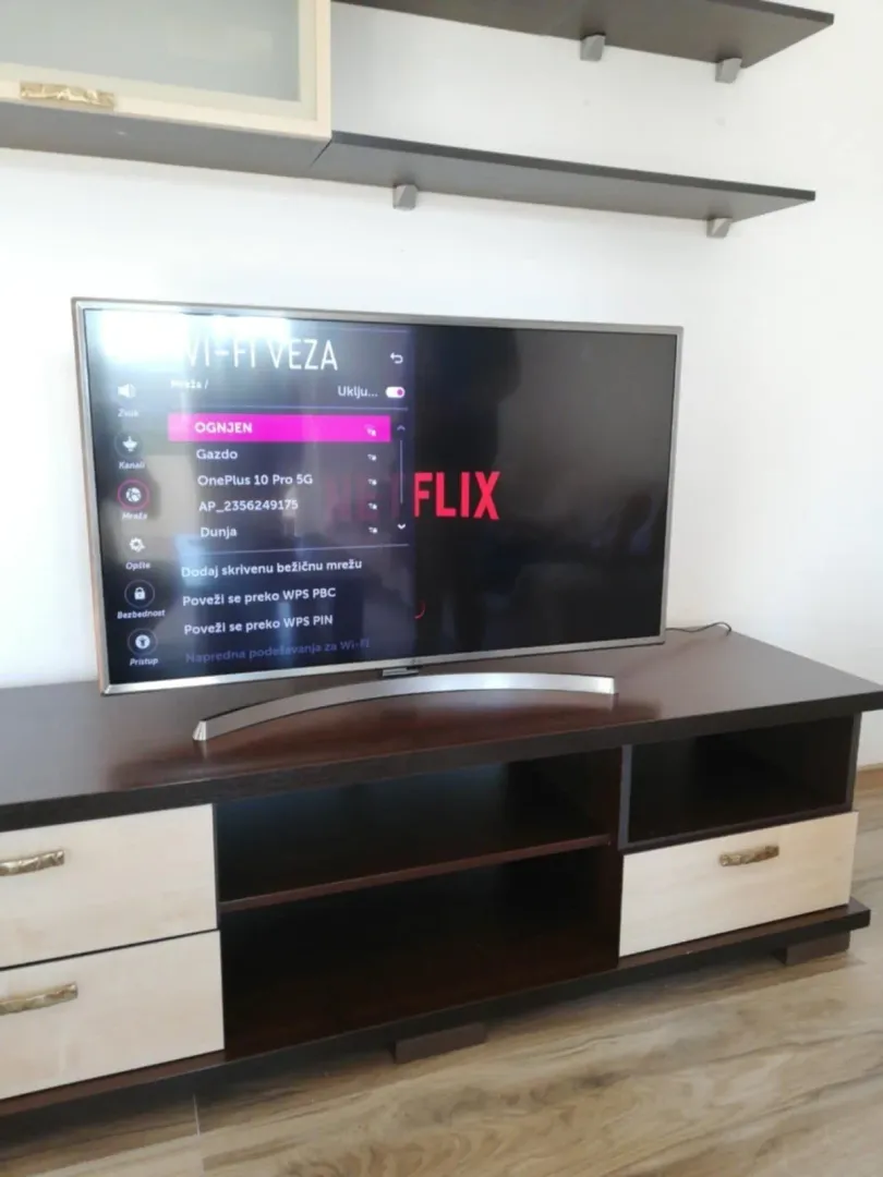 A television on a wooden stand in a living room.