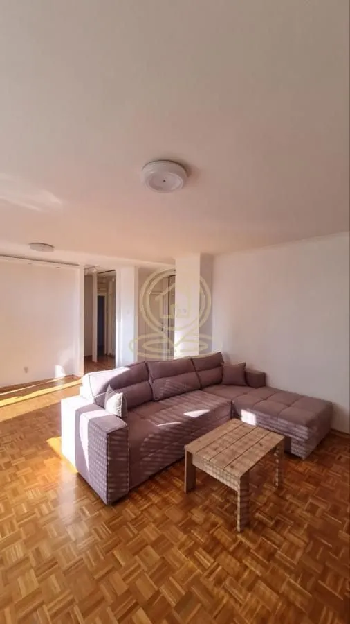 Living room with a sectional sofa and a wooden coffee table.