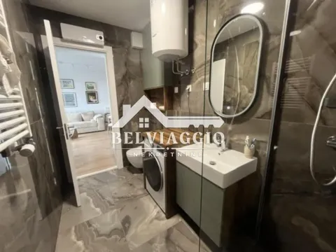 Modern bathroom equipped with a washbasin, mirror, and shower cabin. - image 16