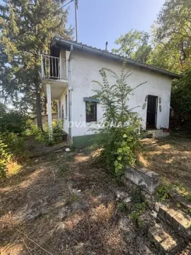 Pogled na spoljašnjost kuće sa dvorištem okruženim zelenilom. - image 4