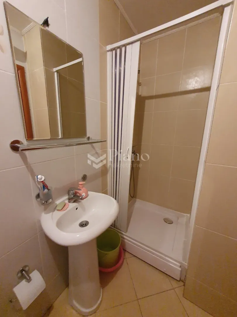 Bathroom equipped with a washbasin, mirror, and shower cabin.